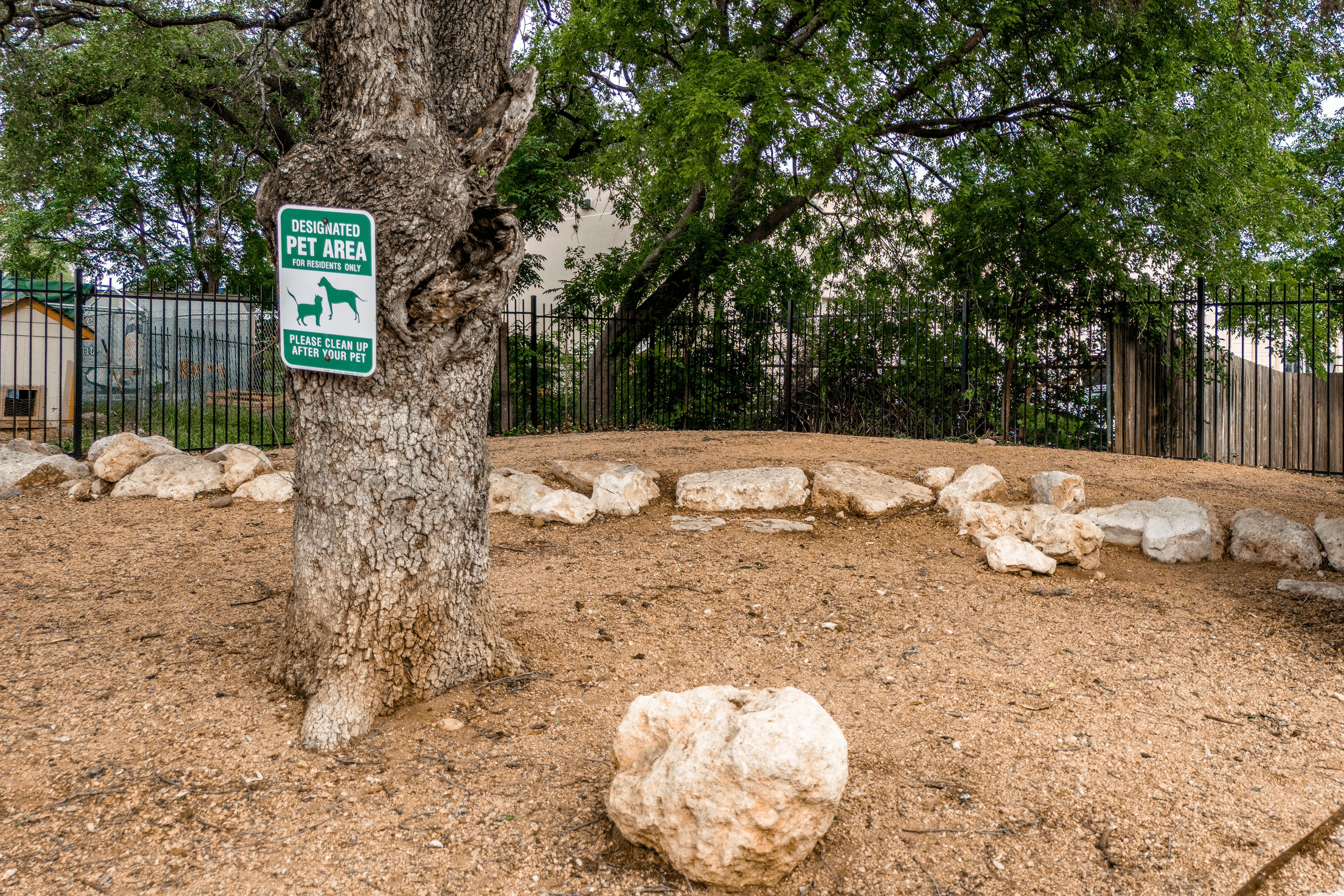 A sign on a tree in a pet area.